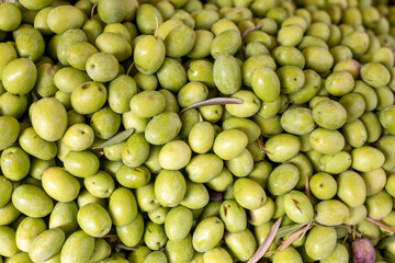 Green fresh olives in a plastic box for sale in the market
