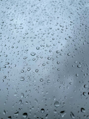 Rainwater drops running down the window glass