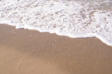Fototapeta na wymiar Soft ocean wave on tropical sandy beach in summer background with copy space