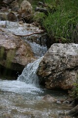 Fototapeta na wymiar Vertical shot of the river flowing over rocks