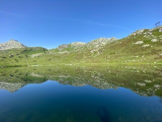 Fototapeta na wymiar Summer atmosphere on the Lago di Rodont lake (Lake Rodont) in the Swiss alpine area of the mountain St. Gotthard Pass (Gotthardpass), Airolo - Canton of Ticino (Tessin), Switzerland (Schweiz)