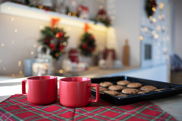 Close up of red mugs with gingerbread cookies in the kitchen Christmas. December 25. Christmas background. Concept; Noel, Merry Christmas, New Years Holidays, Vacations and Weekends