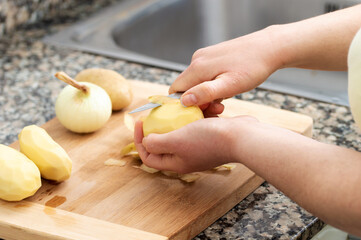  peeling potatoes on the wooden