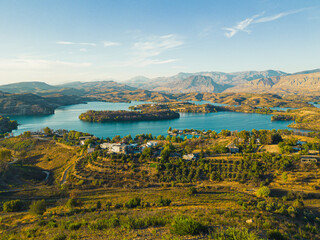 Green Canyon nature reserve in Turkey. Drone view of Green lake Manavgat surrounded by mountain cliffs, flat landscape with buildings and roads. trees. Sunny weather, blue sky. High quality photo