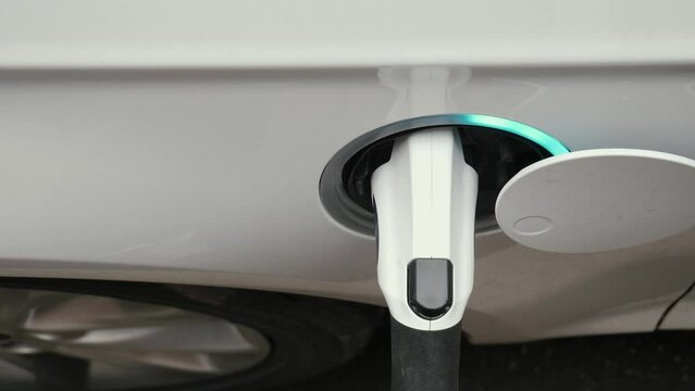 Electric car charging top view. Electric vehicle charging port plugging in car
