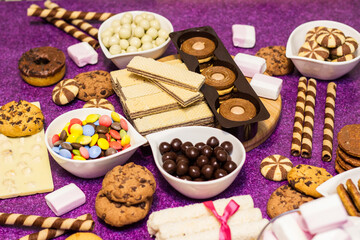 Chocolate and biscuits background. Chocolate and biscuits background. Many pieces of chocolate, candies, cookies, biscuits, cakes, donuts, and other sweets. Milk chocolate and dark chocolate, waffle c