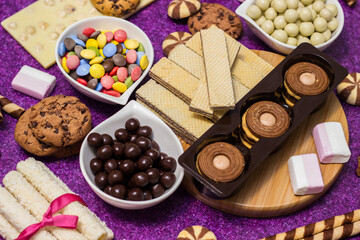 Fototapeta na wymiar Chocolate and biscuits background. Chocolate and biscuits background. Many pieces of chocolate, candies, cookies, biscuits, cakes, donuts, and other sweets. Milk chocolate and dark chocolate, waffle c