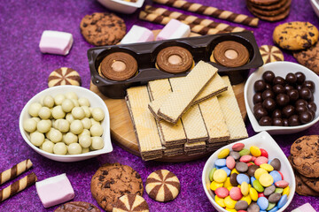 Chocolate and biscuits background. Chocolate and biscuits background. Many pieces of chocolate, candies, cookies, biscuits, cakes, donuts, and other sweets. Milk chocolate and dark chocolate, waffle c