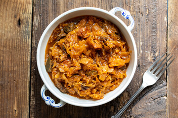 Traditional polish dish of bigos, cabbage with meat, mushrooms and prunes - obrazy, fototapety, plakaty