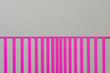 pink paper stencil with wide and narrow stripes on beige paper