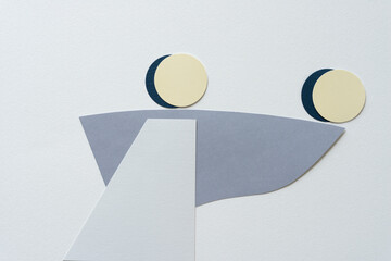 gray paper shapes and paper discs on blank paper