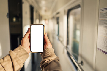 Phone in hands with an isolated screen on the background of the train cabin