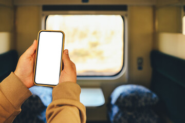 Phone in hands with an isolated screen on the background of the train cabin