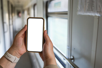 Phone in hands with an isolated screen on the background of the train cabin