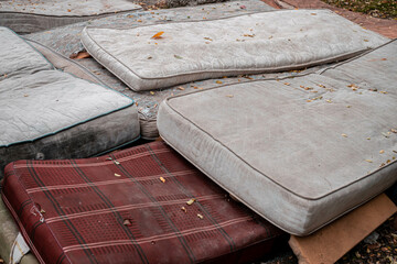 Dump of old mattresses. old dirty mattresses are lying on the ground. Dump of old mattresses