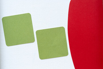two green paper squares with rounded corners and red shape (shadows at L and R edges are intentional)