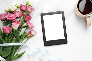 Modern e-book reader, flowers and cup of tea on white table, flat lay