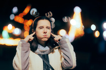 Stressed Woman Annoyed by Christmas Music Covering her Ears. Person finding traditional song...