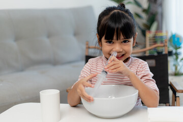 Little asian girl saline nasal wash nose at home. - obrazy, fototapety, plakaty