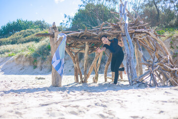 砂浜の小屋から顔を覗かせる女性