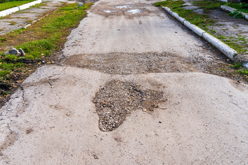 The road is in disrepair with potholes. Background with selective focus as copy space
