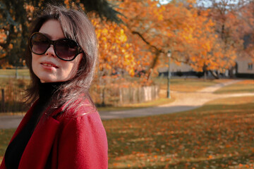 Caucasian girl in a red coat and sunglasses.