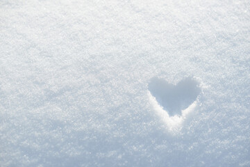 Drawing of a heart in the snow. Frozen heart painted on white snow background. Heart shape, ice or...