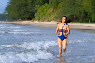 Obraz premium Woman body big with swimsuit happy morning at beach