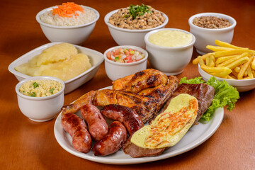 Mixed meal with sun-dried meat with coalho cheese, chicken and sausage with side dishes. Brazilian cuisine.