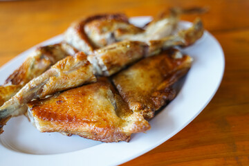 Grilled chicken in white plate on wooden floor - traditional Thai menu  It's a simple and popular dish.