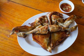 Grilled chicken in white plate on wooden floor - traditional Thai menu  It's a simple and popular dish.