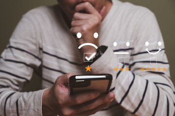 Selective focus at men hand while type on smartphone to give customer satisfaction feedback for...