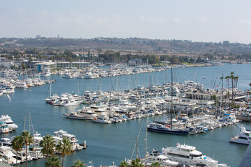 Fototapeta na wymiar Marina Del Rey, California, USA – October 12, 2022: High Close-up View of Yacht Clubs at Marina Del Rey with Beach, Boat Pier Docks, Boats, and Houses