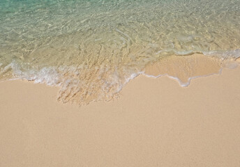 Clear ocean waves on a clean sandy beach.