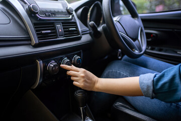Fototapeta na wymiar Turning on car air conditioning system. Hand tuning fm radio button in car panel.