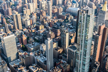 Aerial view of the rooftops of skyscrapers and districts of central Manhattan as well as the streets of a large