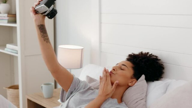 Camera, black woman and selfie in a bed with happy, smile and relax girl posing, playful and having fun in her home. Photography, photographer and woman taking pictures while lying in a bedroom alone