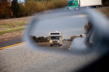 RV through side view mirror on road
