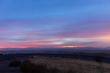 Colorful sunset off curved higway ram. Blue and purple sky at sunset.