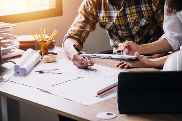 Construction engineer working at blueprint to build large commercial buildings in office. Engineering tools and construction concept.