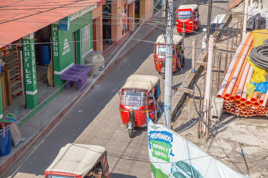 Tuktuk taxis driving down street in Guatemala on January 5, 2016.
