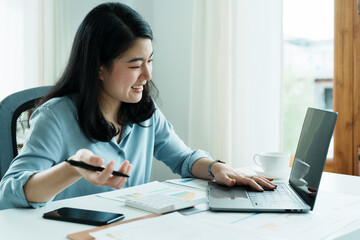 Portrait of a beautiful Asian teenage girl using computer for video conferencing at office.