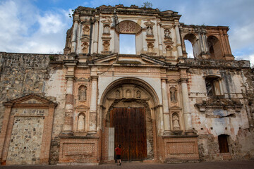 Fototapeta na wymiar Man admires Temple and College of the Company of Jesus in Guatemala