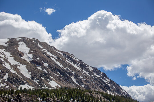 Fluffy clouds over snowy mountain in Spring