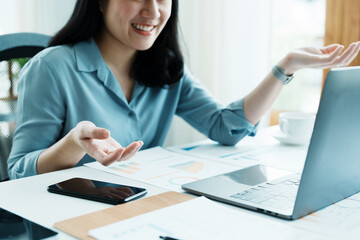 Portrait of a beautiful Asian teenage girl using computer for video conferencing at office
