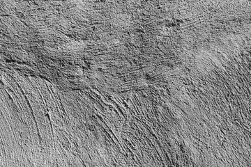 Abstract background from a wall with rough and embossed gray plaster.