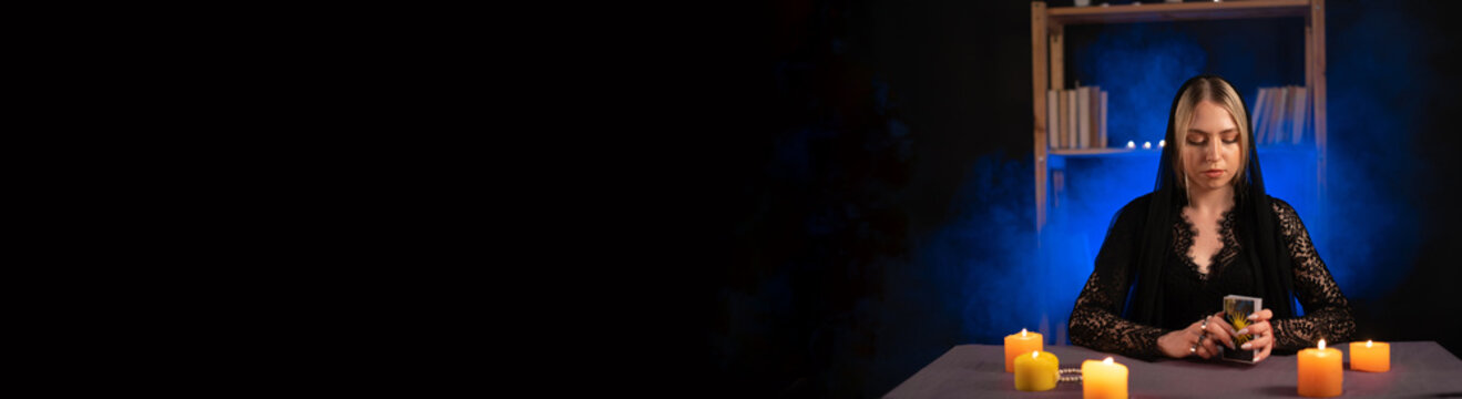 Tarot reader picking tarot cards.Candlelight in dark.Tarot reader or fortune teller reading and forecasting concept.