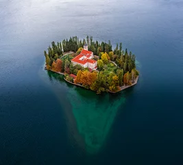 Fotobehang Visovac, Croatia - Aerial view of the beautiful island Visovac Christian monastery in Krka National Park on a bright autumn morning with colorful autumn foliage and turquise water © zgphotography
