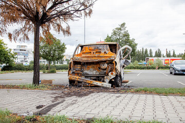 Minibus after a fire, burnt body and interior of the car. Burnt rusty car after fire or accident. Car after the fire, crime of vandalism, riots. Arson car. Accident on the road due to speeding.