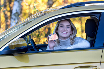 Young woman with a driving license document.